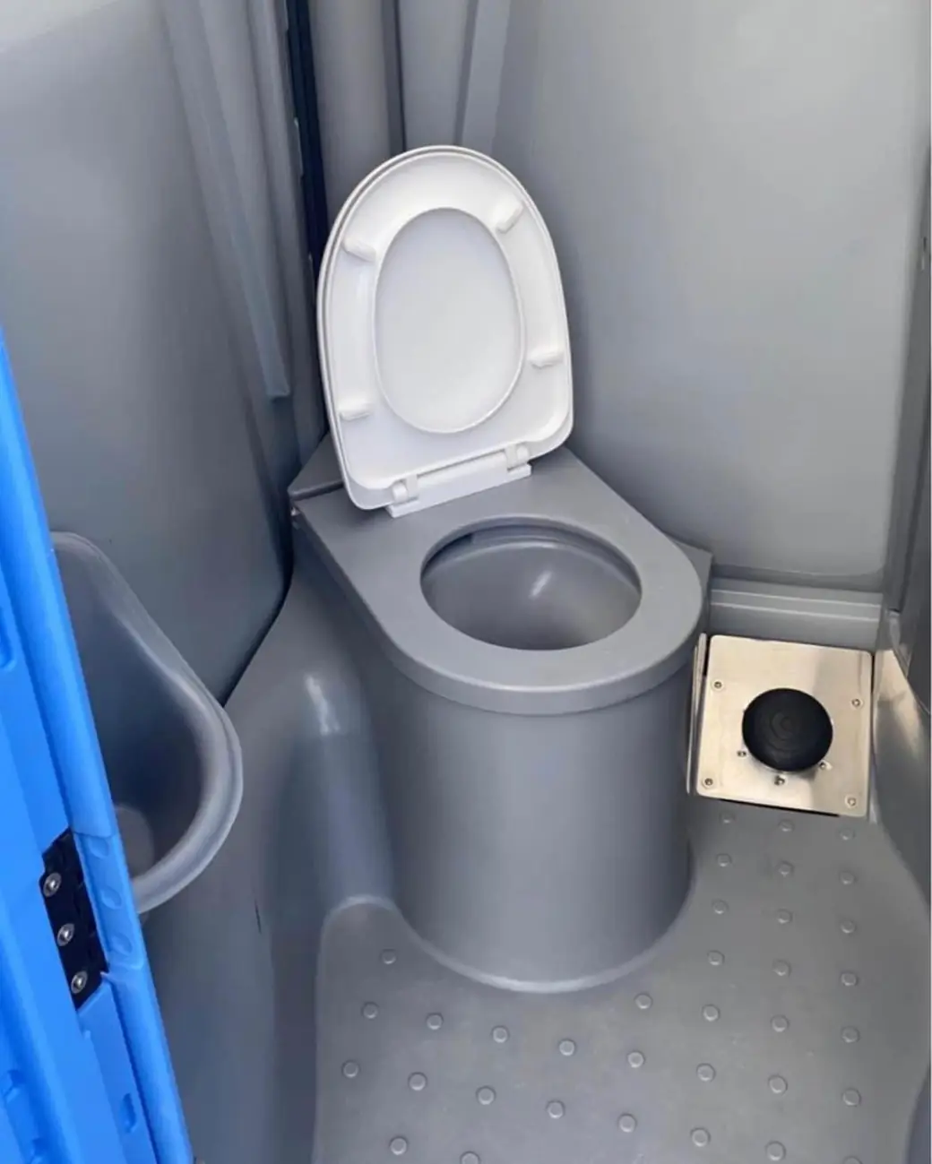 Gray portable toilet interior with a white seat and textured non-slip floor