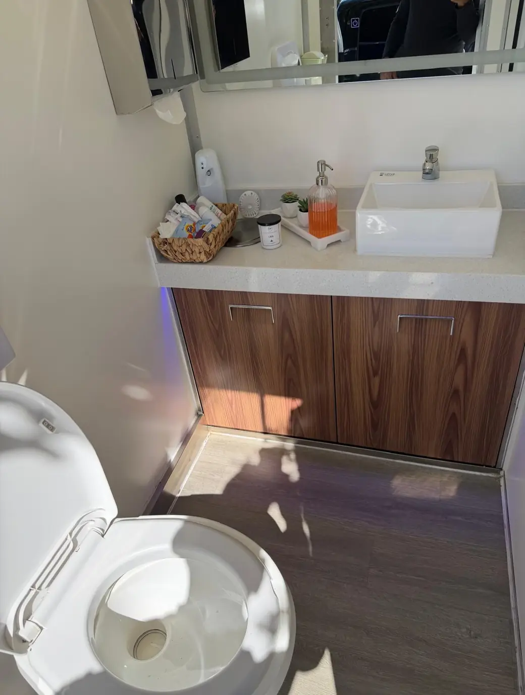 Restroom trailer vanity with a vessel sink, soap and an amenity basket